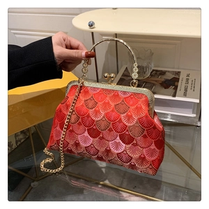 Detail of red cheongsam evening bag with shell embroidery and golden ring handle