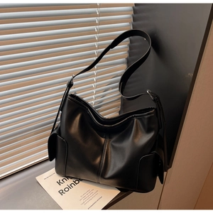 Macro shot of large black soft PU leather tote bag showing side pockets and wide strap