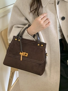 Deep brown suede crossbody handbag with white contrast stitching and gold lock detail