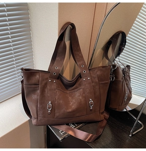 Detail of vintage coffee brown tote bag with silver eyelets and textured PU leather finish