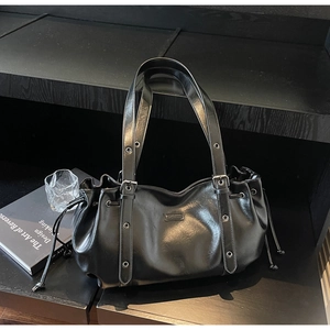 Détail du sac en cuir PU noir avec cordon de serrage et œillets métalliques stylés