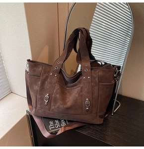 Close-up of retro brown tote bag with vintage silver studs and matte leather finish