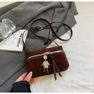 Detail of vintage brown suede box bag featuring silver robot charm and metal zipper
