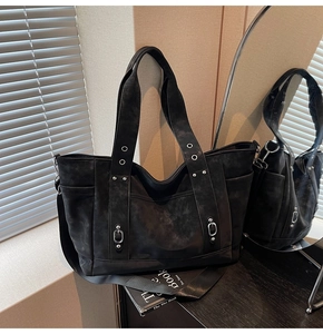 Detailed close-up of retro black tote bag featuring matte suede texture and metal eyelets