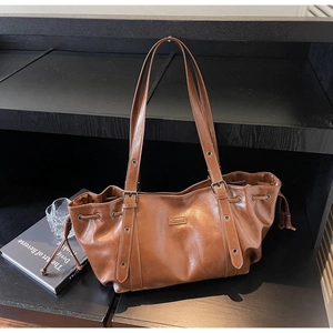 Détail d'un sac cabas en cuir PU marron avec texture à cordon et œillets métalliques