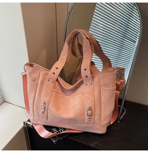 Detail of light pink tote bag with silver rivets and wide adjustable nylon shoulder strap