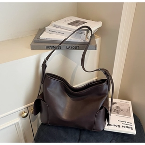 Detailed macro view of dark brown PU leather texture and side pocket of the shoulder bag
