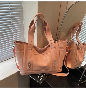 Detailed macro view of peach canvas tote bag texture with metal rivets and shoulder strap