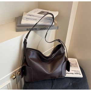 Detail shot of the adjustable strap and side pocket on this dark brown soft PU leather tote