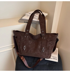 Detail of vintage brown tote bag with retro textures and wide adjustable shoulder strap