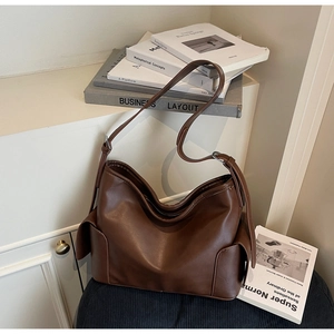 Detailed view of the dark brown PU leather handbag with adjustable strap and vintage buckle
