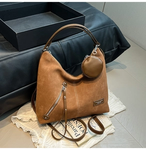 Detail view of large brown vintage leather tote bag with a small coin purse and contrast stitching