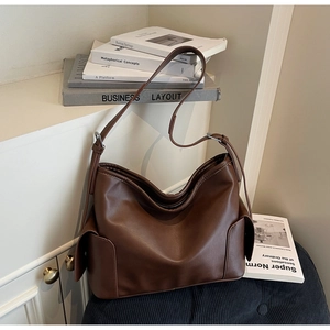 Detail view of large dark brown PU leather tote bag with side pockets and adjustable strap