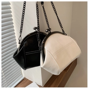Detail of shell-shaped bags with cross stitching and metallic ball clasp closure