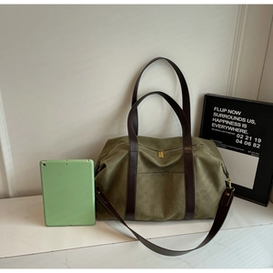 Detail of olive green canvas tote bag showing tablet compartment and leather handle straps