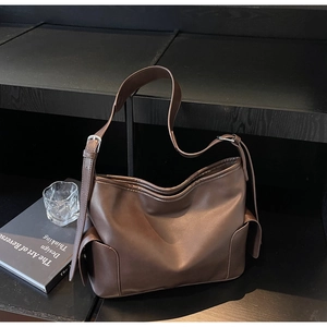 Detail of coffee brown large PU leather tote bag with flap side pockets and adjustable strap