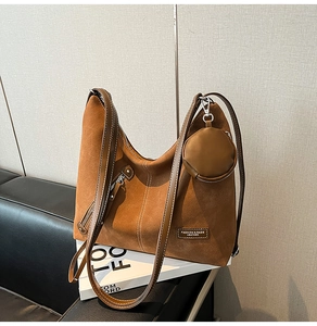 Detail of vintage brown suede tote bag with contrast stitching and small round pouch