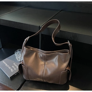 Detail view of dark brown PU leather tote with adjustable strap and side pockets
