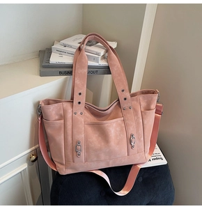 Pink canvas tote bag detail with silver metal rings and functional side pocket