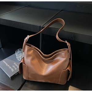 Detail of brown PU leather hobo bag showing large side pockets and silver hardware