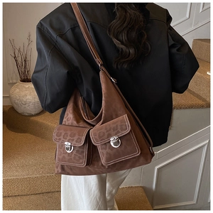 Brown suede tote bag with leopard texture and two buckle pockets on the model's shoulder