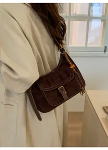 Detail of dark brown tote bag with contrast stitching and bohemian beaded tassel