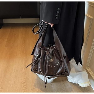 Detail shot of vintage coffee brown bucket bag with silver studs and adjustable strap