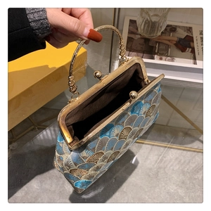 Detailed view of the blue and gold brocade silk bag interior with metal handle
