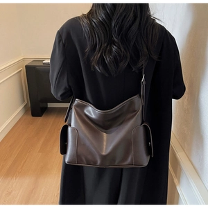 Detail view of deep brown PU leather tote bag with large side pockets and adjustable strap