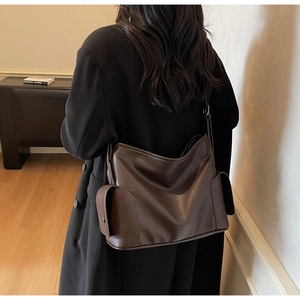 Detailed back view of a large brown PU leather tote bag worn with a black blazer