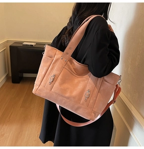 Detail of pink canvas tote bag with metal studs and wide fabric shoulder strap