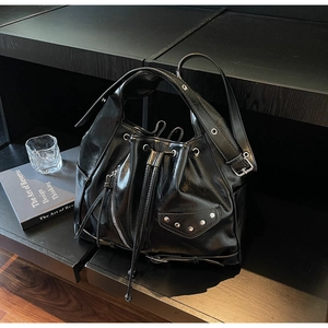 Close-up of black punk tote bag with silver rivets, zippers and belt buckle details