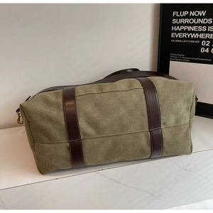 Close-up of army green canvas travel bag with leather straps and metal hardware detail