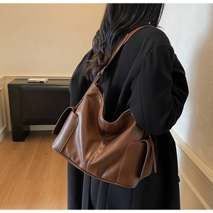 Macro view of dark brown leather hobo bag showing spacious side pocket and rich texture