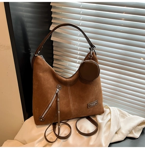 Detail of a vintage large brown suede hobo bag with fringe zipper and small coin purse