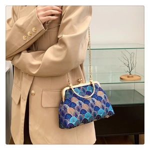 Detail of vintage floral jacquard fabric and gold clasp on a retro kiss-lock handbag