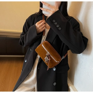Brown suede crossbody bag featuring a silver robot pendant charm on a compact box shape