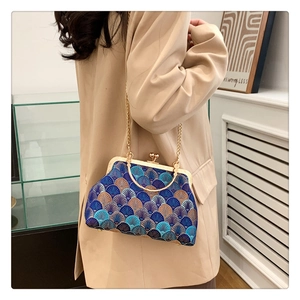 Close-up of vintage frame bag with intricate blue fan embroidery and gold metal clasp