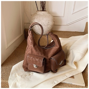 Detailed close-up of brown vintage hobo bag with dual flap pockets and silver buckles