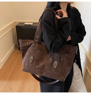 Detail of a large vintage dark brown tote bag with matte texture and dual handles