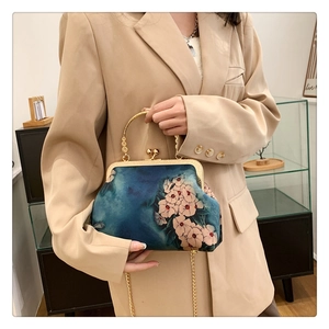 Λεπτομέρεια vintage μπλε μεταξωτής τσάντας με λουλούδια, μεταλλική λαβή και χρυσό κούμπωμα