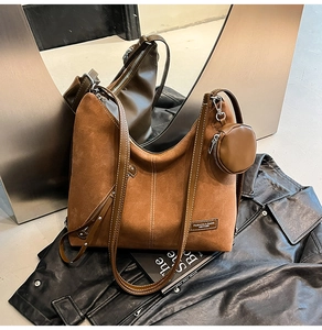 Detail of brown suede tote bag with white contrast stitching and a small round coin purse