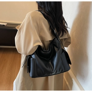Black large capacity faux leather hobo bag side view on female model in minimalist room