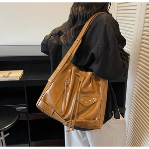 Detail of vintage brown bucket bag with motorcycle style rivets and leather texture