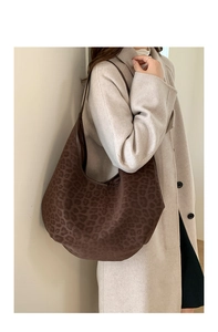 Detail of vintage brown leopard print hobo bag worn with elegant beige winter coat