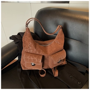 Detail of hobo bag with leopard print texture, dual front pockets and contrast stitching