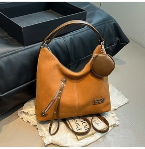 Detail of caramel suede hobo bag with fringe zipper, coin purse, and smooth leather strap
