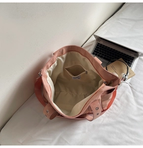 Detail view of pink tote bag interior featuring wide beige lining and a zipper pocket