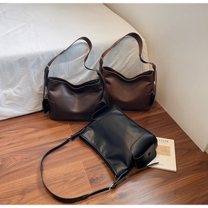 Detail view of large PU leather tote bags in black, dark brown, and brown with side pockets