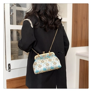 Elegant vintage frame bag with fan patterns shown worn as a crossbody accessory
